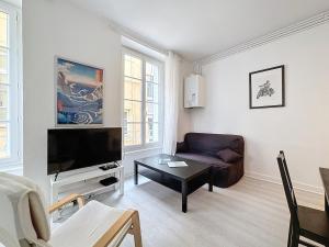 un soggiorno con divano e TV a schermo piatto di Hyper-centre apartment Treille 29 a Clermont-Ferrand