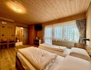 En eller flere senge i et værelse på B&B Family Accommodation Canazei SKI-IN SKI-OUT