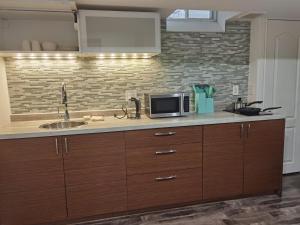 a kitchen counter with a sink and a microwave at Suite! Separate Entry, 1 Parking in Newmarket