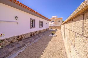 een stenen steunmuur naast een gebouw bij Rentaliday Villa Alta in Tijoco de Abajo