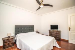 een slaapkamer met een bed en een plafondventilator bij Rentaliday Villa Alta in Tijoco de Abajo