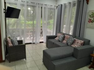 a living room with a couch and a chair at Casa Arenas in Manuel Antonio