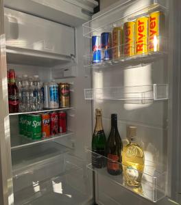an open refrigerator filled with drinks and soda cans at Karolinska Apartment City Center in Ostrava +5 photos
