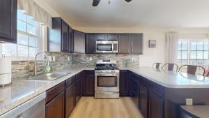 una cucina con armadietti in legno ed elettrodomestici in acciaio inossidabile di West Atlantic City Bayview House a Pleasantville