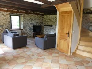 a living room with two chairs and a door at La Maison de Louise in Altillac