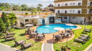 una vista aérea de un complejo con piscina, mesas y sillas en Asunción Gran Hotel en Ciudad del Este