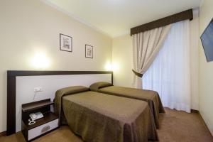 a hotel room with two beds and a window at Hotel Boccascena in Genoa