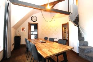 a dining room with a wooden table and chairs at Contactless Check In - Spacious New-York Style Penthouse Apartment in Leeds City Centre in Leeds +2 photos