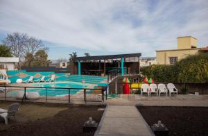 ein Swimmingpool mit Stühlen und einem Gebäude in der Unterkunft Realty vacacional 61 in Villa Carlos Paz