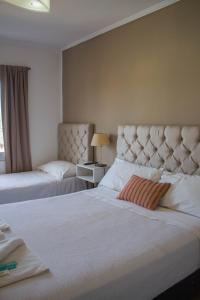 ein Hotelzimmer mit zwei Betten und einem Fenster in der Unterkunft Realty vacacional 61 in Villa Carlos Paz