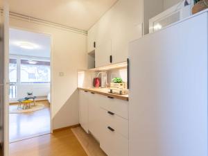 eine Küche mit weißen Schränken und ein Flur mit einem Tisch in der Unterkunft Appartement 4 pers. proche centre ville & téléphérique - FR-1-296-473 in Saint-Lary-Soulan