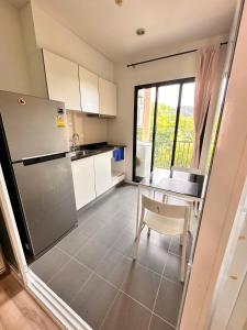 a kitchen with a refrigerator and a table with a chair at the base updown一卧 in Phuket Town