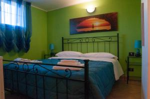 a bedroom with a bed with green walls at B&B L'Orizzonte in Civitavecchia