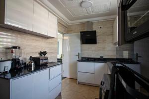 a kitchen with white cabinets and a counter top at Vienama Residence 2 mins drive to Labadi Beach in Accra +83 photos