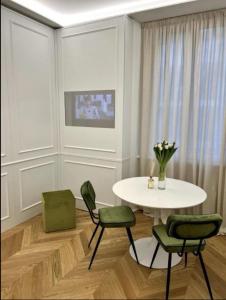 a dining room with a table and green chairs at Isolabella Apartment in Milan
