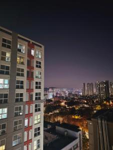 a tall building with a view of a city at night at Incheon City Hall Station Full Option Lovely House in Incheon