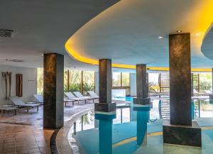 a swimming pool with pillars in a hotel lobby at GPRO Valparaiso Palace & Spa in Palma de Mallorca