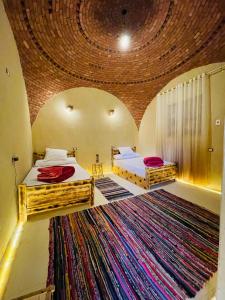 two beds in a room with a large rug at Shasha Siwa Retreat & Thermal Spring in Siwa +60 photos
