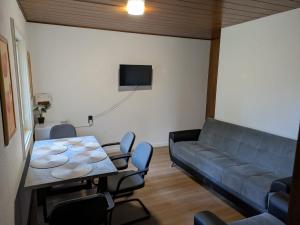 a living room with a couch and a table and chairs at Ruhige Unterkunft im Norden von Neumünster in Neumünster