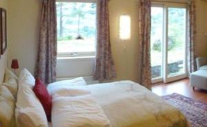sypialnia z łóżkiem i dużym oknem w obiekcie Solund Leileghetshotell w mieście Hardbakke