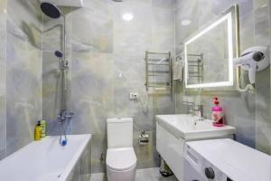 a bathroom with a toilet and a sink and a mirror at RIVIERA apartment near complex TSUM and GUM in Bishkek