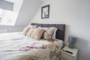 a white bedroom with a bed with pillows at Whisky lovers retreat-3 Bed House in Rothes in Rothes