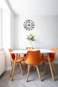 a dining room with a white table and orange chairs at Whisky lovers retreat-3 Bed House in Rothes in Rothes +19 photos
