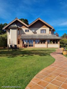 a house with a large yard with a pathway at Pousada Bliss House - Opções de suites com hidromassagem in Campos do Jordão