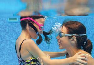 deux jeunes femmes debout à côté d'une piscine dans l'établissement Nilai Youth City Fully Air-Con Cozy 2 Bedroom HomeStay, à Nilai