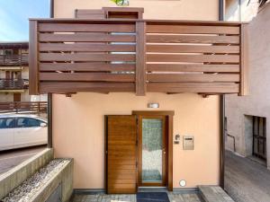 a house with a wooden door on a building at Casa al Vicolo [vicino al Lago di Garda] in Cavedine