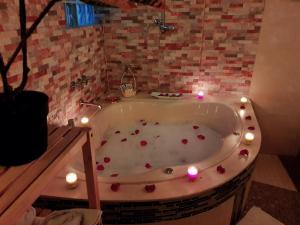 un bagno con vasca decorata con candele e rose di Hotel Cusco Museo a Cuzco Altre 20 foto