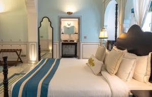 a bedroom with a large bed with white pillows at Padmaa Jaipur in Jaipur