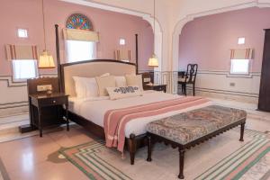 a bedroom with a bed and a table and a chair at Padmaa Jaipur in Jaipur