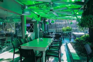 a restaurant with green lighting and tables and chairs at Dunia Suites Cartagena in Cartagena de Indias