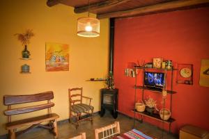 a room with a red wall with a chair and a stove at Cabaña Kenty Wasy in Humahuaca