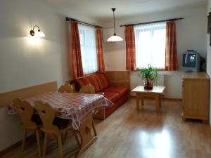 a living room with a red couch and a table at Apperlehof in Villabassa