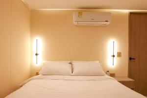a bedroom with a white bed with two lights at Dunia Suites Cartagena in Cartagena de Indias +7 photos