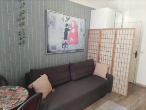 een woonkamer met een bank en een schilderij aan de muur bij studio idéal visite de Paris in Ivry-sur-Seine