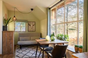a living room with a table and a couch at Summio Vakantiepark Herperduin in Herpen