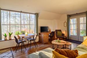 a living room with a couch and a tv at Summio Vakantiepark Herperduin in Herpen