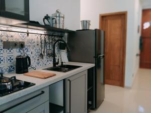 a kitchen with a sink and a refrigerator at Casa Kusuma in Prambanan