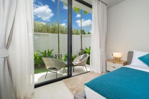 une chambre avec un lit et un balcon avec un patio dans l'établissement Bang Tao Botanica Modern Loft 3 bd, à Ban Pak Lak 30 autres photos