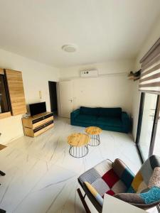 a living room with a couch and two tables at Brand new, Finikoudes area in Larnaka