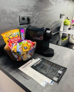 a counter top with a basket of chips and a toaster at Karolinska Apartment City Center in Ostrava