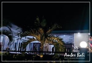 een palmboom voor een gebouw 's nachts bij Amber Bali - Villa with serenity in Tabanan