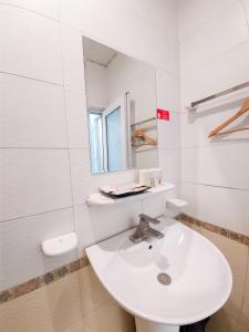 a white bathroom with a sink and a mirror at Khách sạn Thế Kỷ Mới in Hanoi