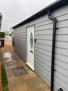 eine Garage mit einem Tor an der Seite eines Hauses in der Unterkunft Brightons view in Saxlingham Thorpe