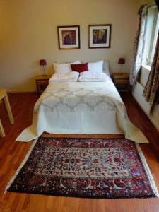 - une chambre avec un lit et un tapis au sol dans l'établissement Solund Leileghetshotell, à Hardbakke