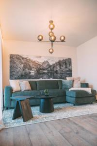 a living room with a green couch and a table at LIVALPIN Style in Garmisch-Partenkirchen