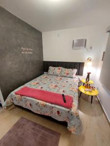 a bedroom with a bed with a red blanket at Studio Nosso Sonho in Cabo Frio